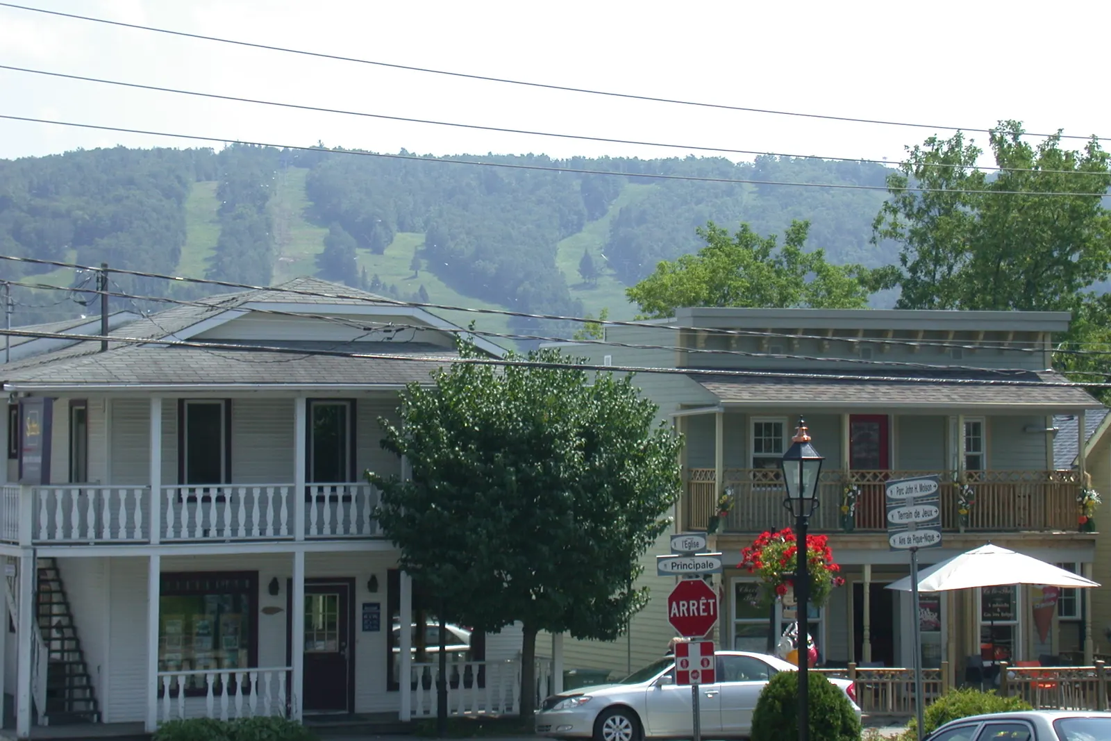 De vieilles maisons de bois du village de Saint-Sauveur, les pistes de ski de la montagne derrière.