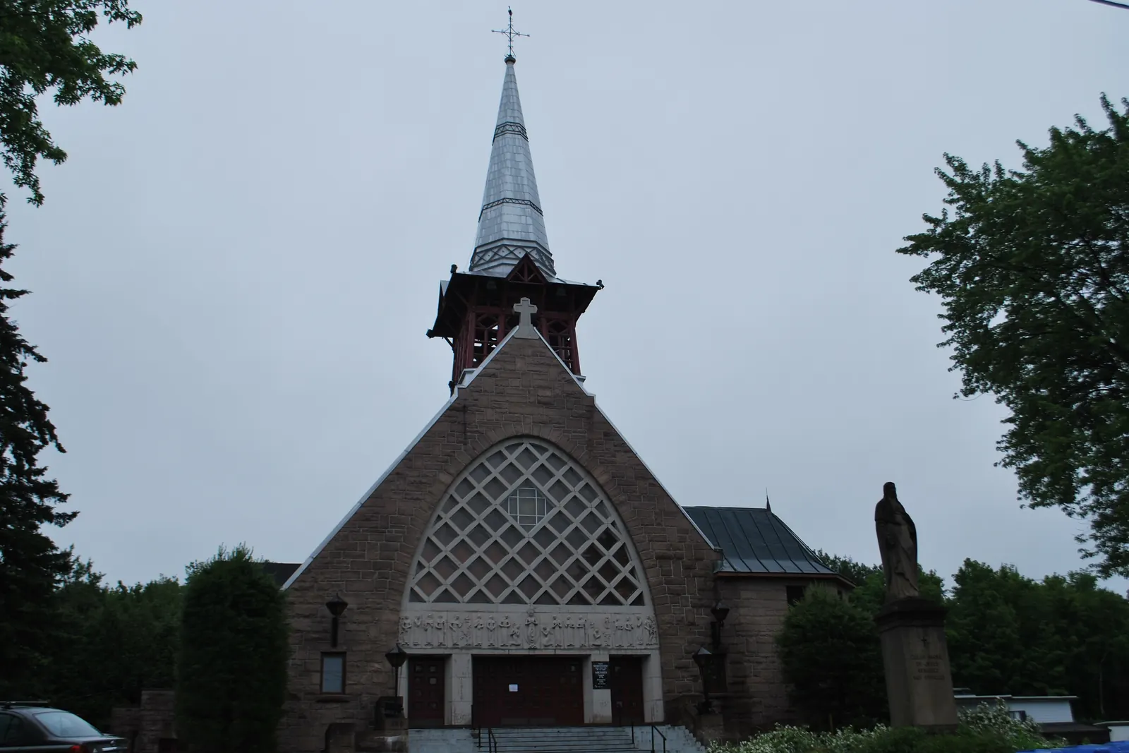 La façade de pierre de l’église de Sainte-Adèle, sa rosace et son clocher.